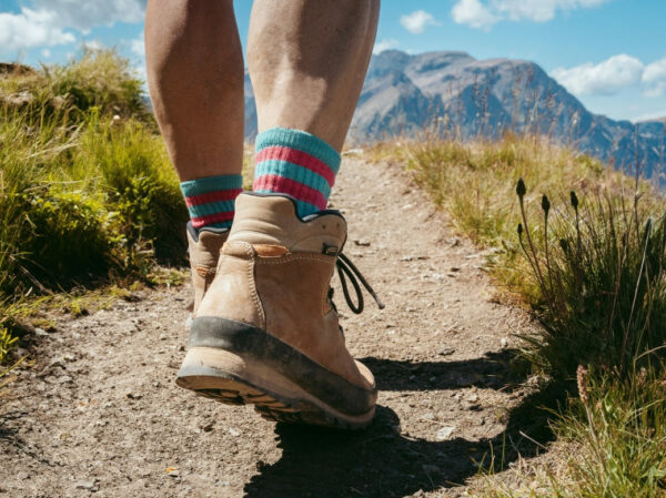 cadrage sur les pieds d'un randonneur avec en arrière plan un paysage de montagne dans les hautes alpes